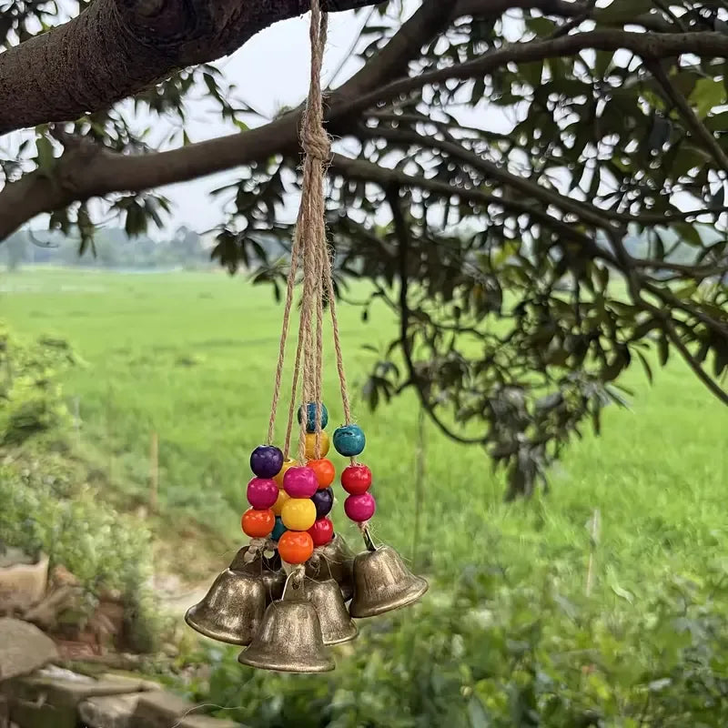 Handmade Bohemian Wind Chime, featuring jute rope with brass bells and colorful wooden beads, rings melodiously in the gentle breeze, adding natural romance to your home.